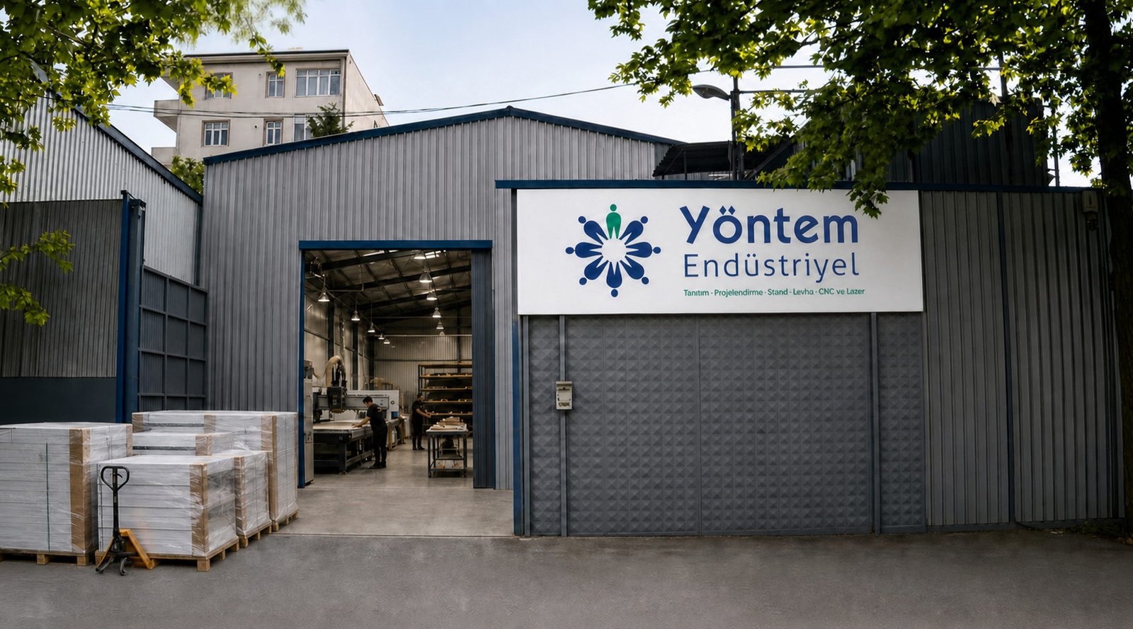 Yöntem Endüstriyel üretim tesisinin tabelalı giriş cephesi ve açık sevkiyat kapısı